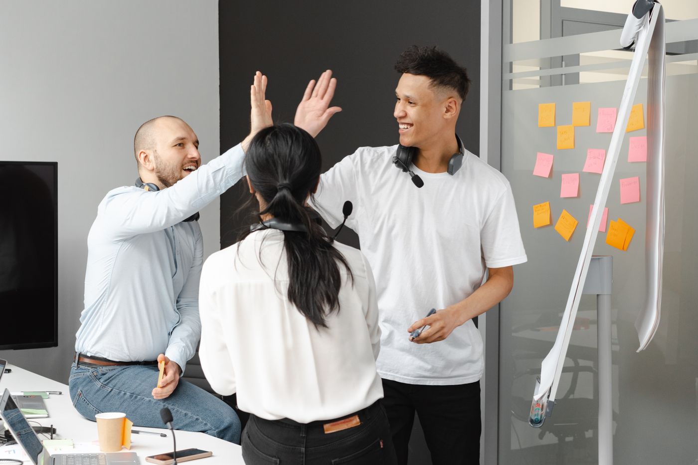 Colleagues high-fiving in a bright office